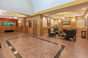 A lobby with a large aquarium, wooden paneling, a seating area with chairs, and a reception desk. - Holiday Inn Express & Suites Corpus Christi NW - Calallen by IHG (Corpus Christi)