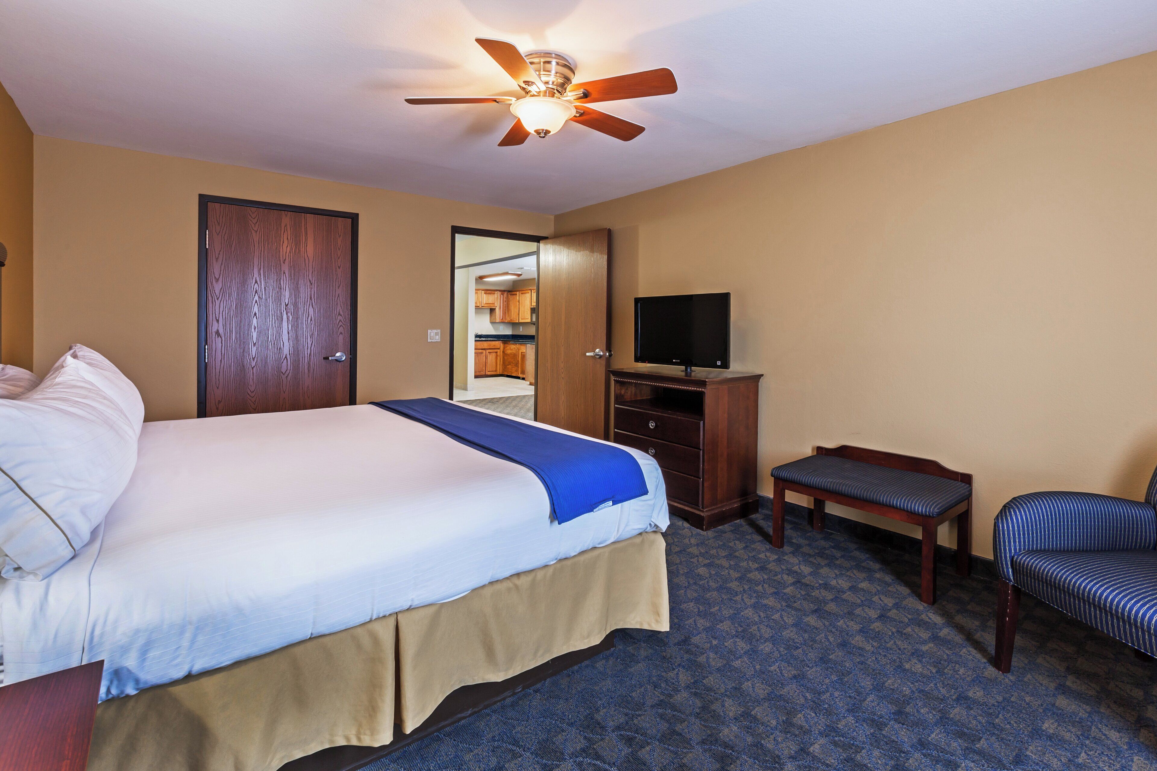 A hotel room with a bed, a television, a desk, and a chair.