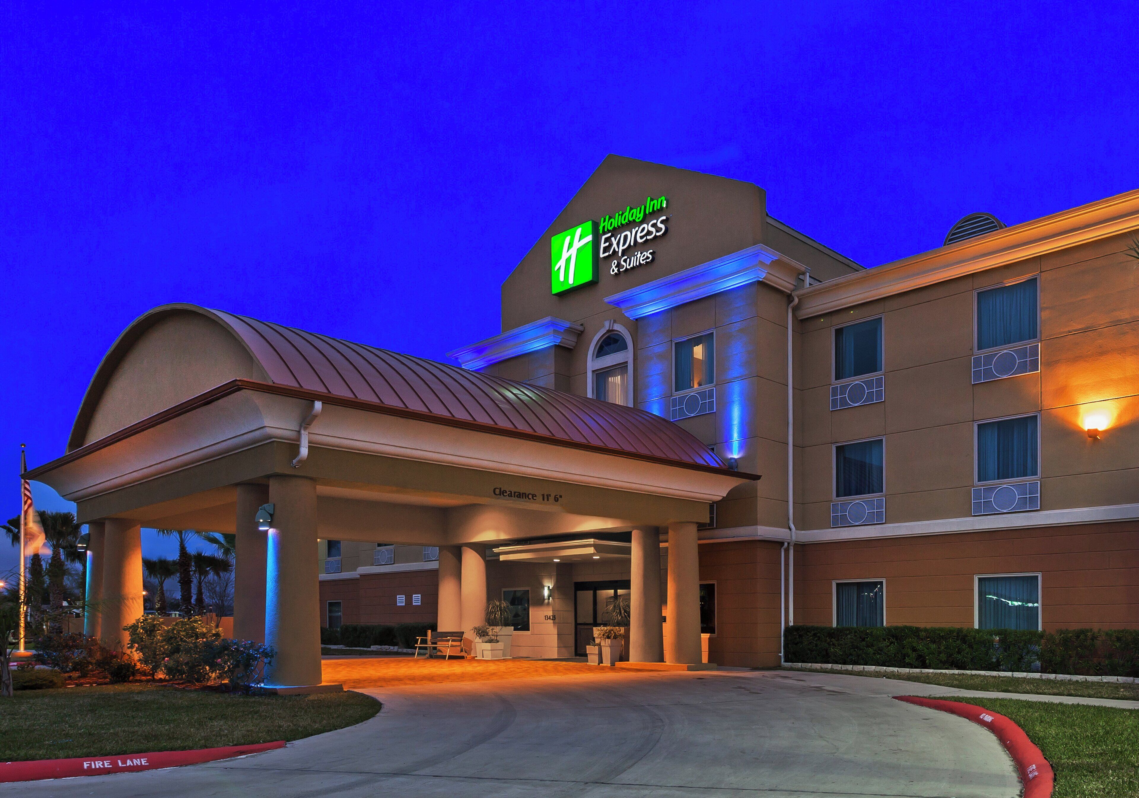 A Holiday Inn Express & Suites building with a covered entrance, clear signage, and a fire lane.