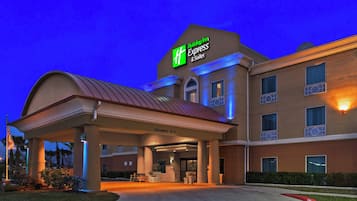 A Holiday Inn Express & Suites building with a covered entrance, clear signage, and a fire lane.