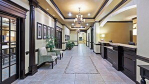A hotel lobby with a reception desk, seating area, and a hallway leading to the rooms. - Holiday Inn Express Hotel & Suites Victoria by IHG (Victoria)