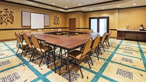 A conference room with a large table, chairs, a whiteboard, and a door. - Holiday Inn Express Hotel & Suites Victoria by IHG (Victoria)