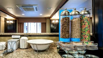 A breakfast buffet area with various food items and containers.