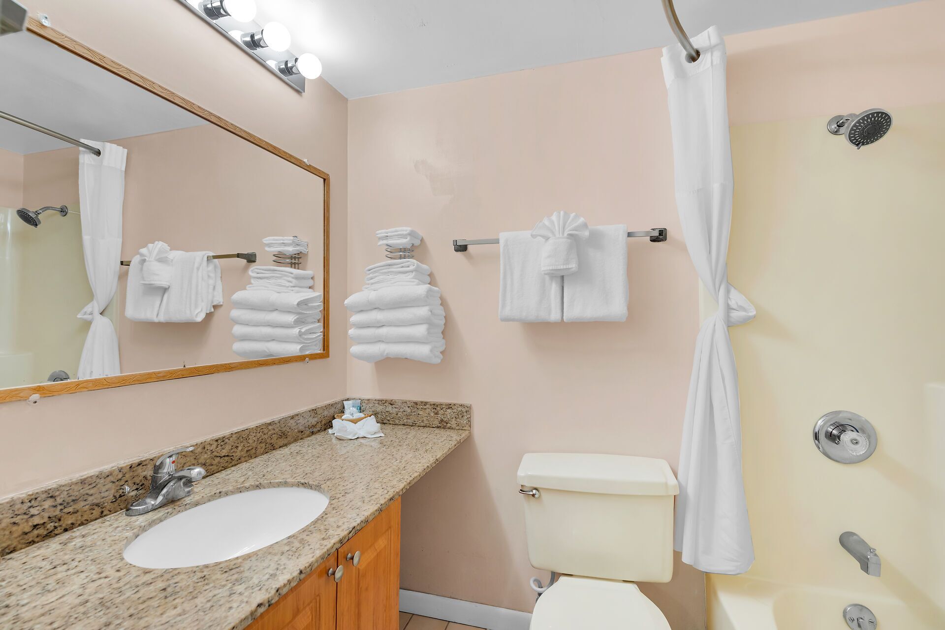 Un baño con lavabo, espejo, toallero, inodoro y cortina de ducha.