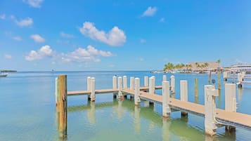 A pier extending into calm waters with a clear sky.