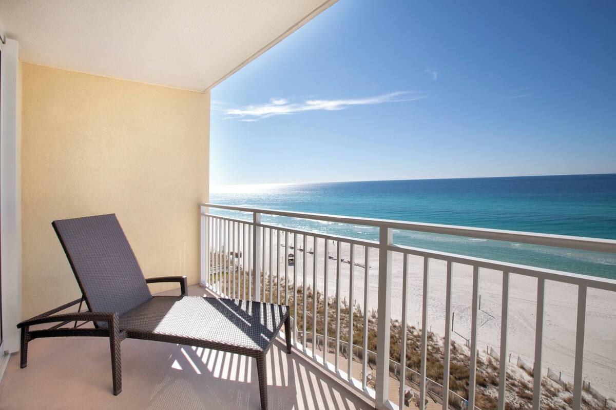 Ein Balkon mit Blick auf Strand und Meer.