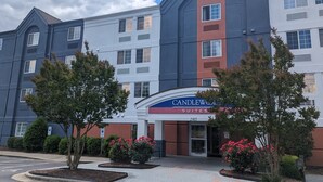 A multi-story hotel with a modern design, featuring a prominent entrance with a sign reading "Candlewood Suites." - Candlewood Suites Wilson by IHG (Wilson)