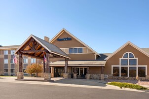 A hotel with a prominent American flag, a covered entrance, and a sign reading "AmericInn."