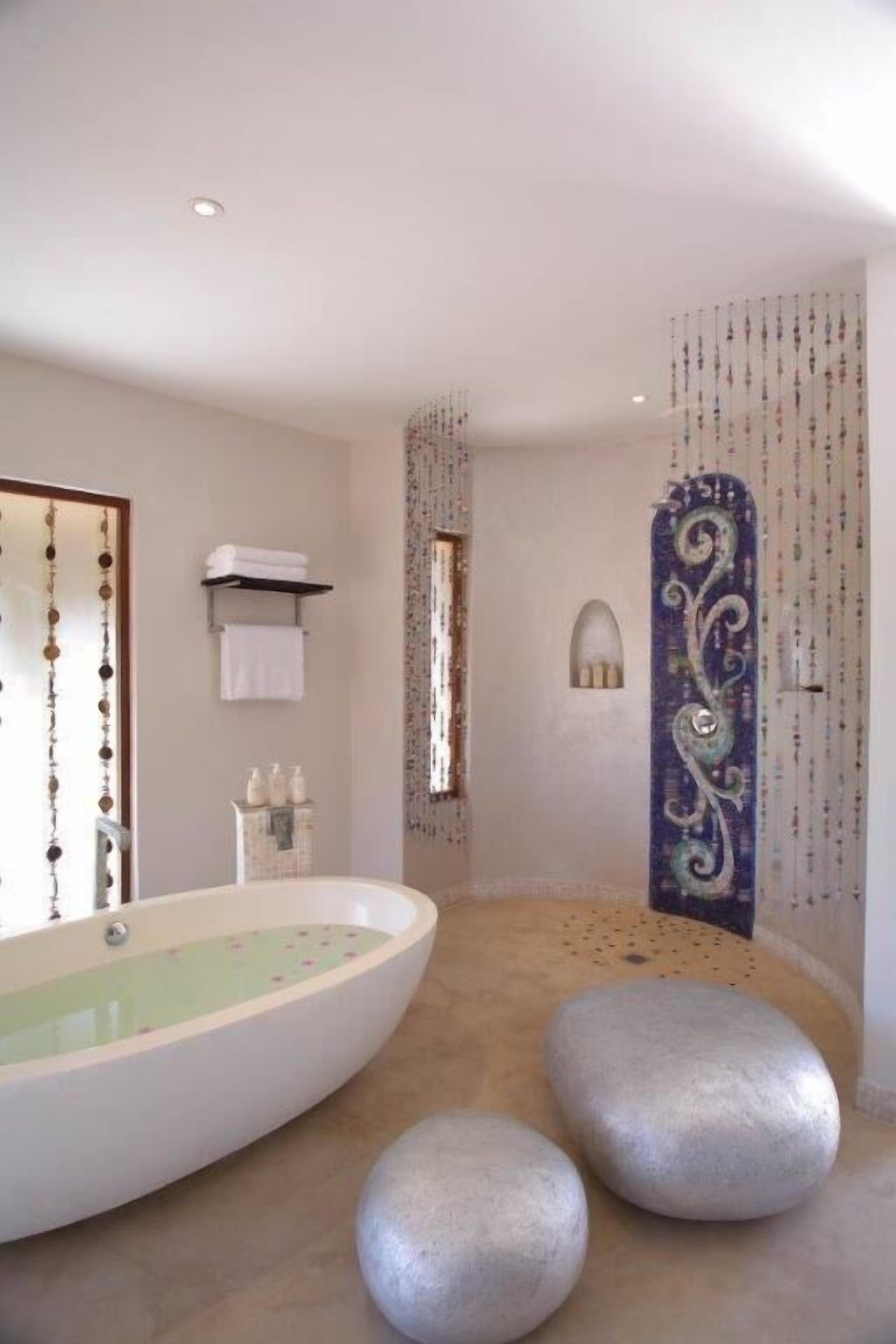 A modern bathroom with a freestanding bathtub, a towel rack, and decorative wall panels.