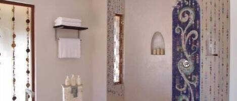 A modern bathroom with a freestanding bathtub, a towel rack, and decorative wall panels.
