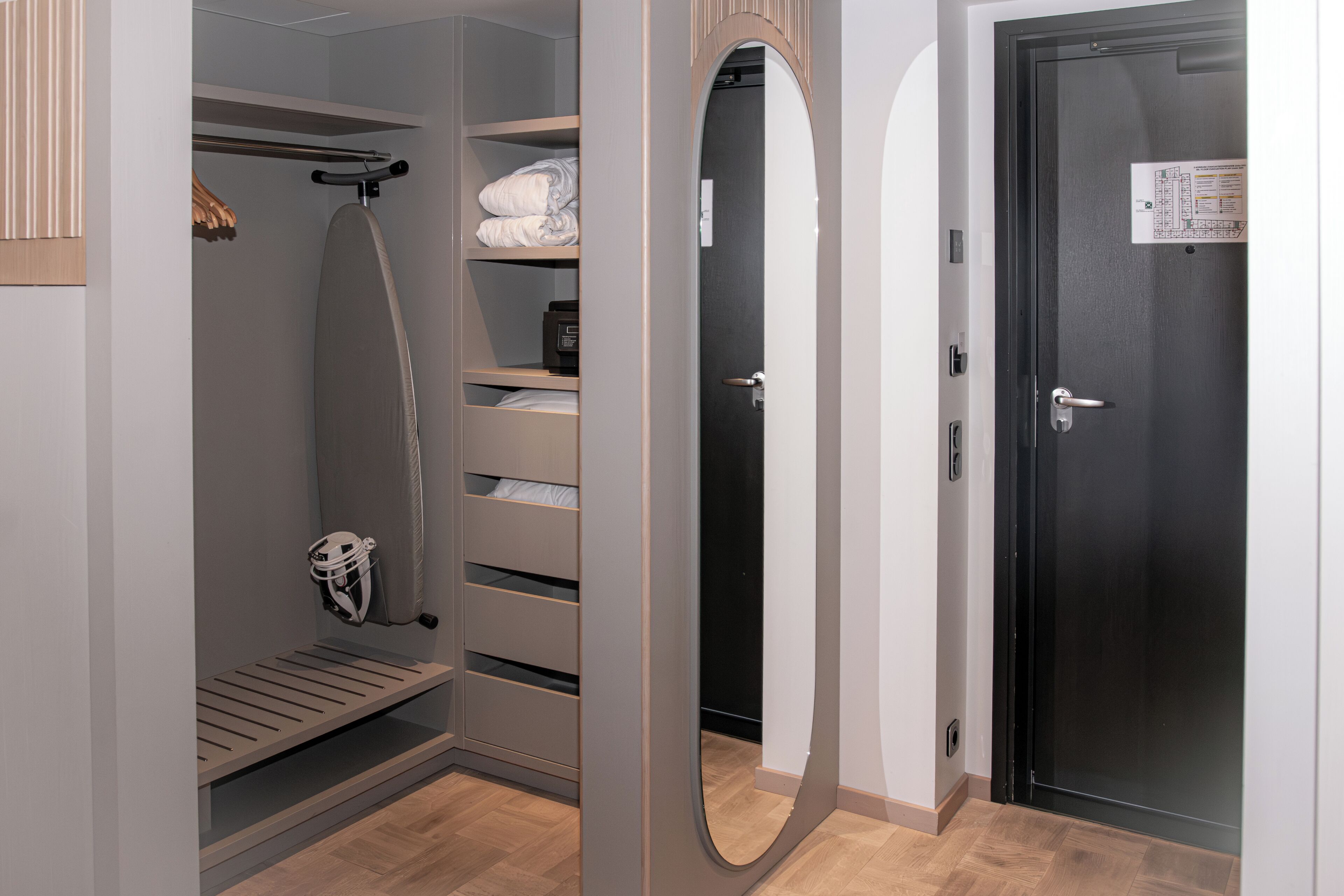 A walk-in closet with shelves, a hanging rack, and a mirror.