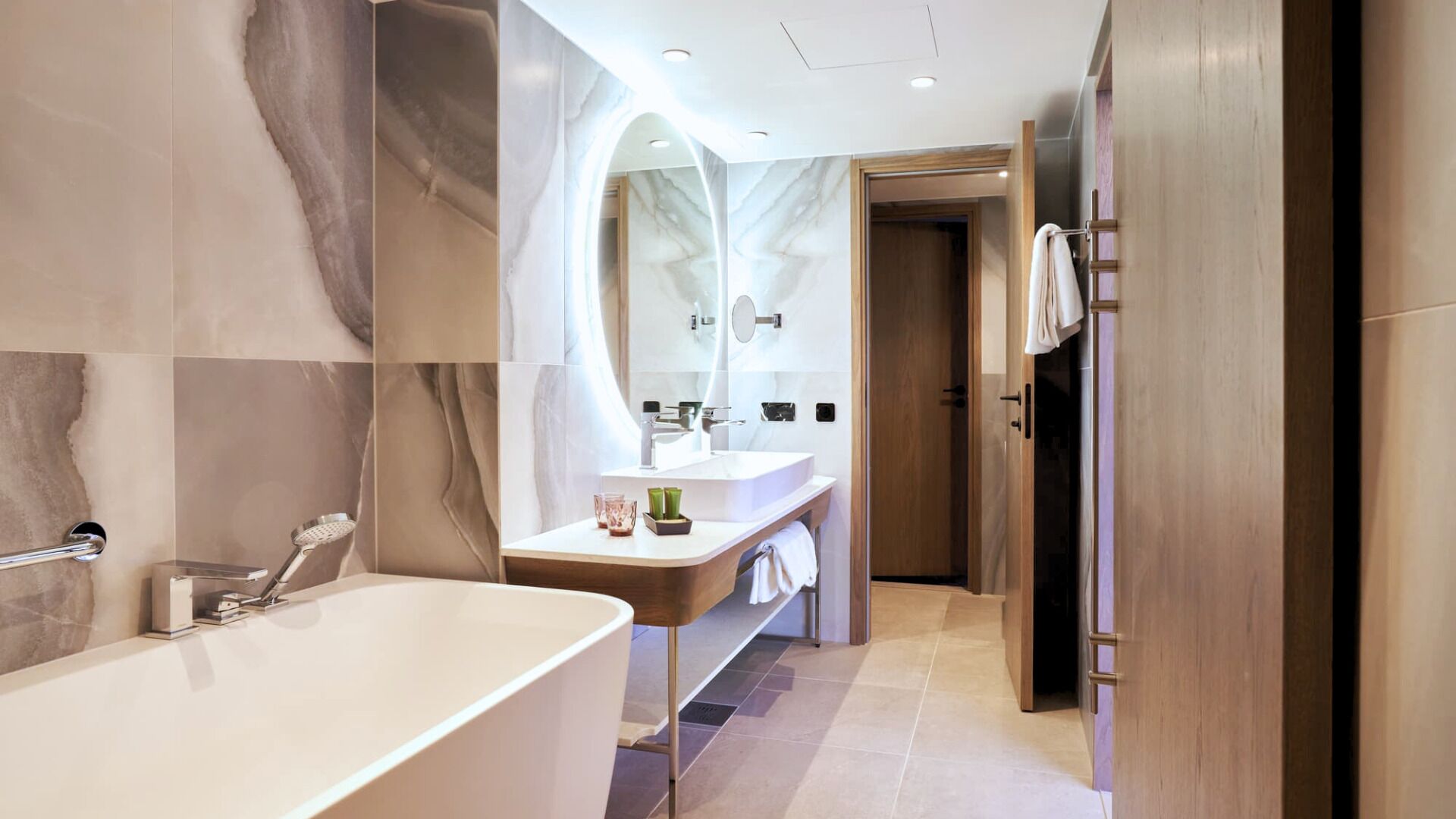 A modern bathroom with a freestanding bathtub, a vanity with a mirror, and a walk-in shower.