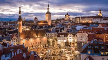 A historic town square with prominent towers and a festive market scene.
