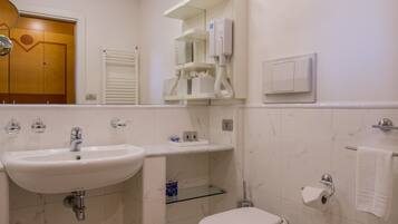 Ein Badezimmer mit Waschbecken, Toilette, Bidet und Spiegel.
