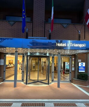 The entrance of Hotel i Triangoli with a revolving door, a Best Western sign, and flags of the EU and Italy. - Best Western Hotel I Triangoli (Rome)