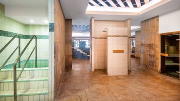Un moderno vestíbulo de hotel con una escalera azulejada, zona de ducha y vistas al exterior.