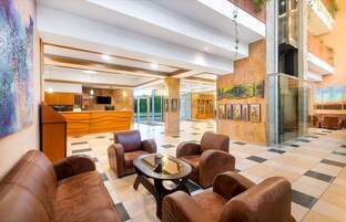 A lobby with a checkered floor, leather seating, a reception desk, and artwork on the walls.