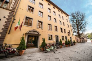 Un hotel con fachada amarilla, numerosas ventanas y un letrero que dice "San Luca Palace Hotel".