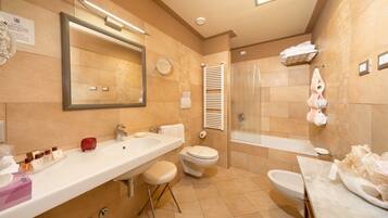Un baño moderno con un espejo grande, un lavabo, un inodoro y una bañera.