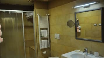 Une salle de bain équipée d’une douche, de toilettes, d’un lavabo, d’un porte-serviettes et d’un miroir.