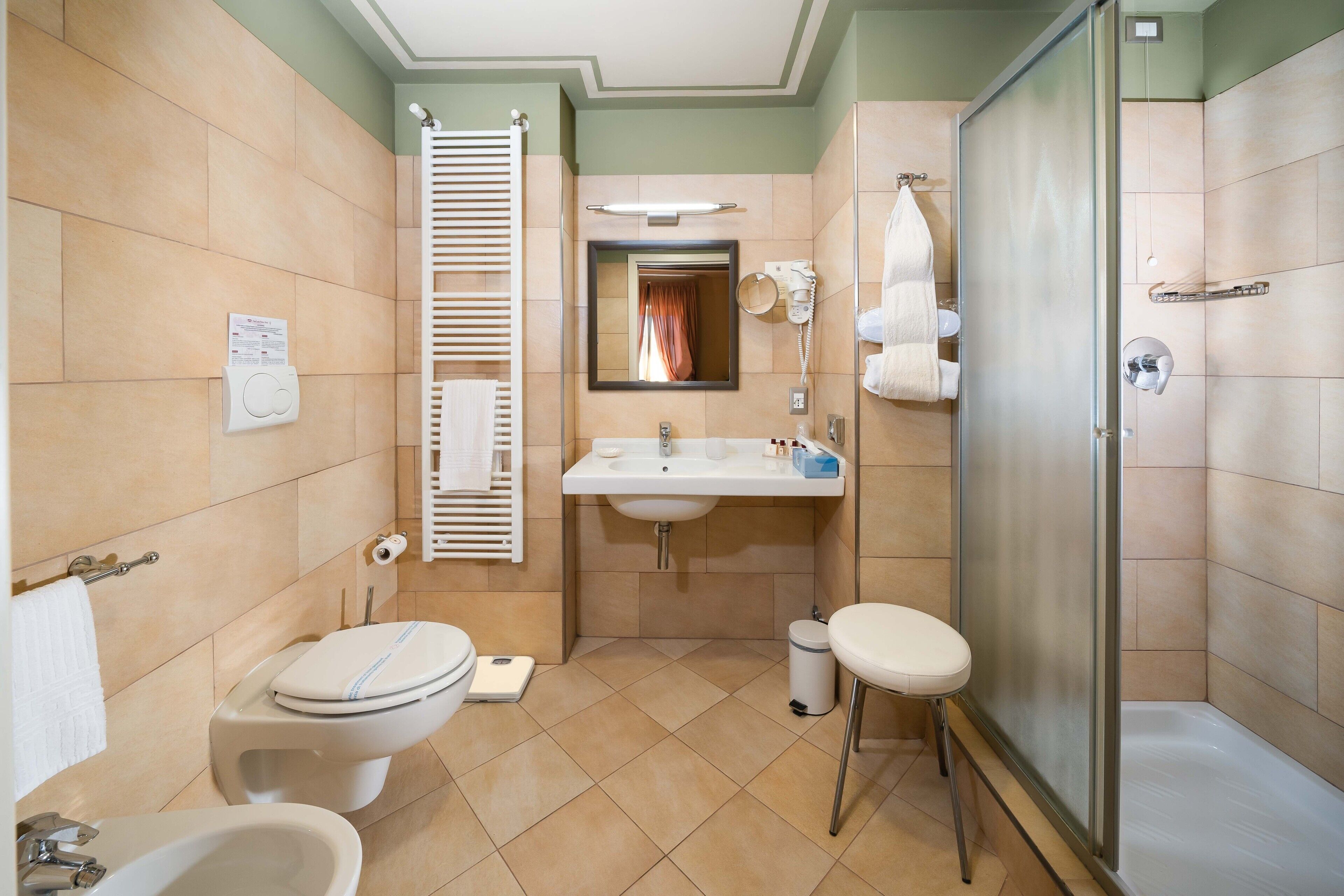 Un baño con inodoro, lavamanos y ducha.