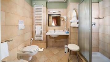 Un baño con inodoro, lavamanos y ducha.