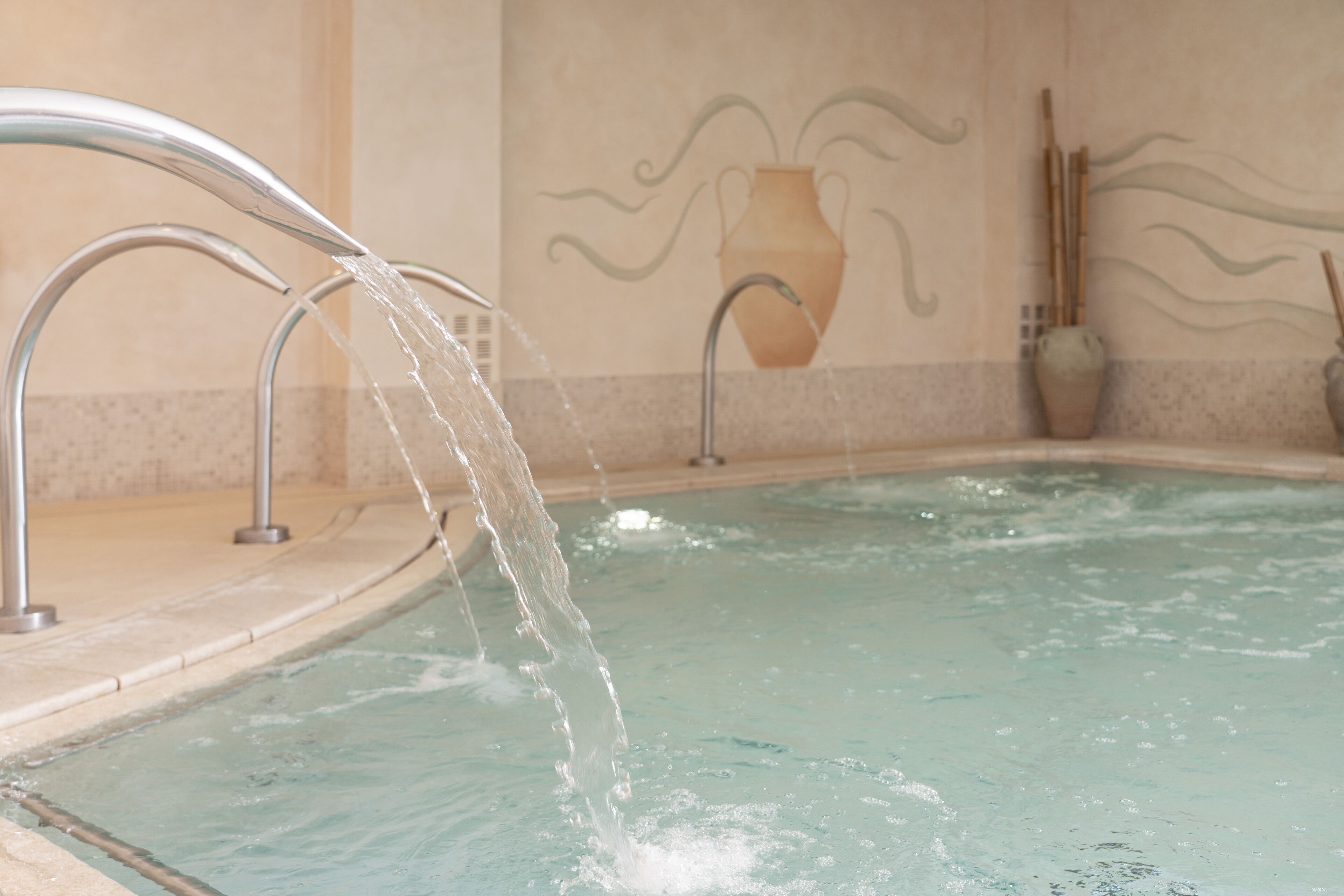 A spa pool with water flowing from two faucets.