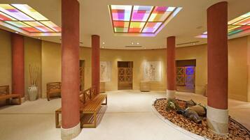 A spacious lobby with high ceilings, large pillars, and a central seating area.