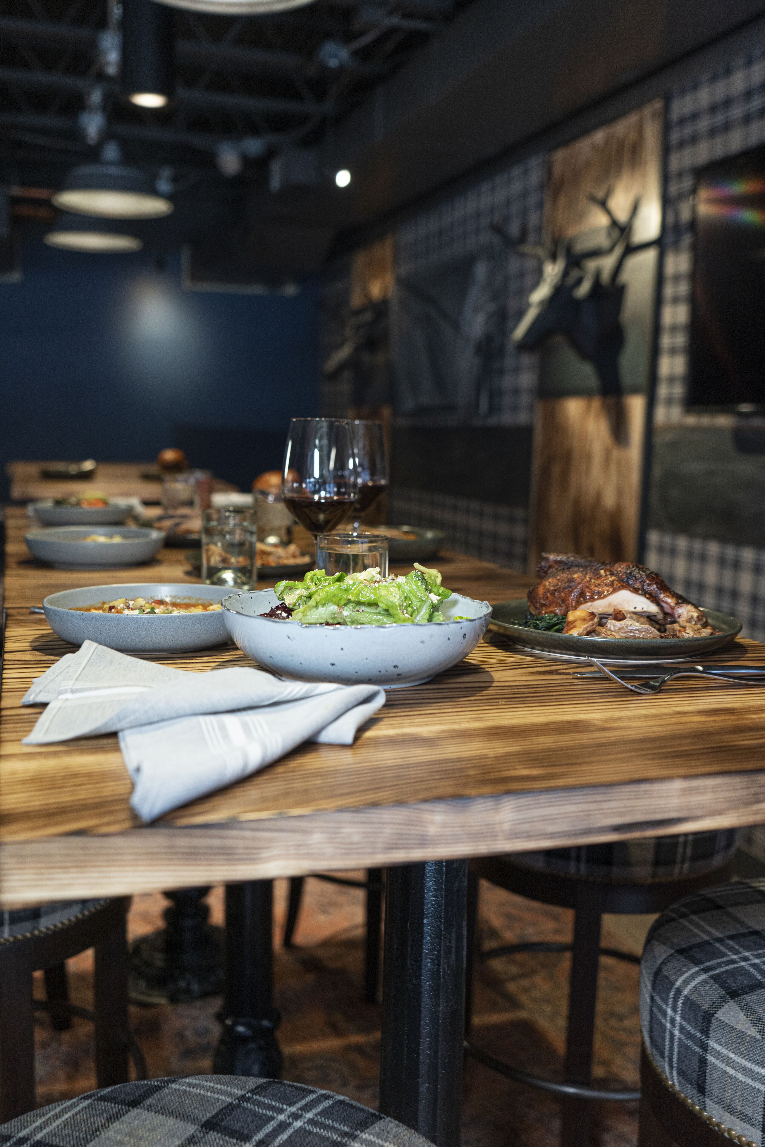 A dining table set with various dishes, glasses, and a wine glass.