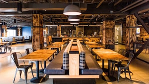 A spacious cafeteria with long communal tables and benches, surrounded by chairs. - Gravity Haus Breckenridge (Breckenridge)