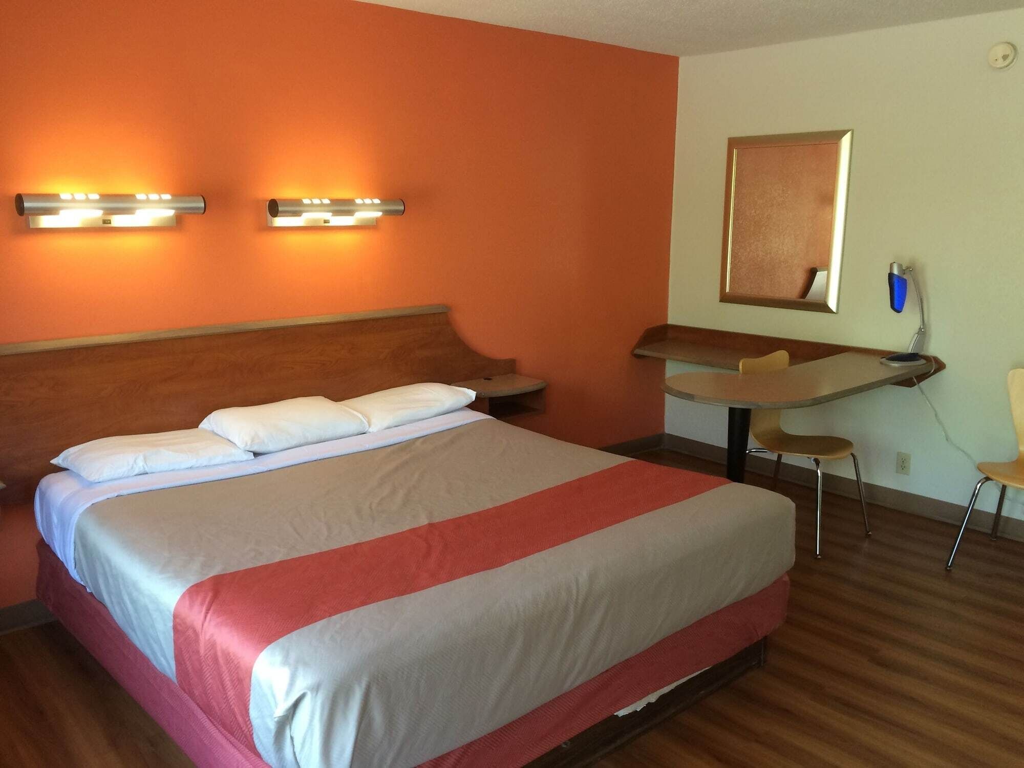 A hotel room with a bed, a desk, and a chair.