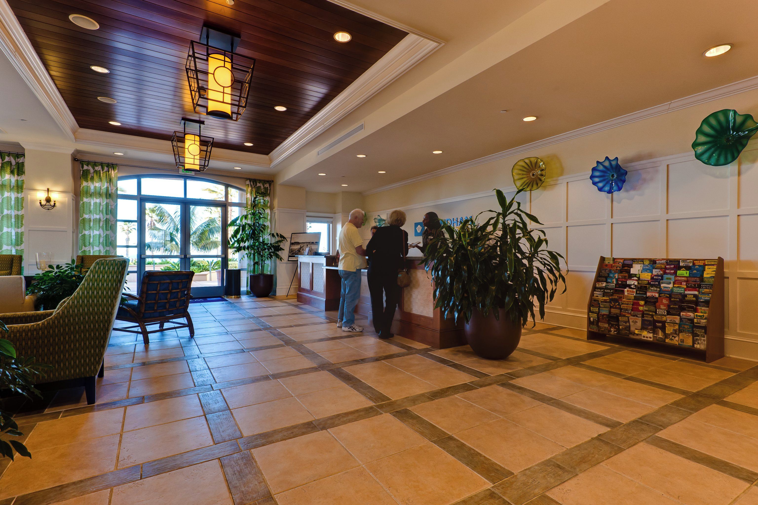 A lobby with a reception desk, seating area, and a bulletin board with various items.