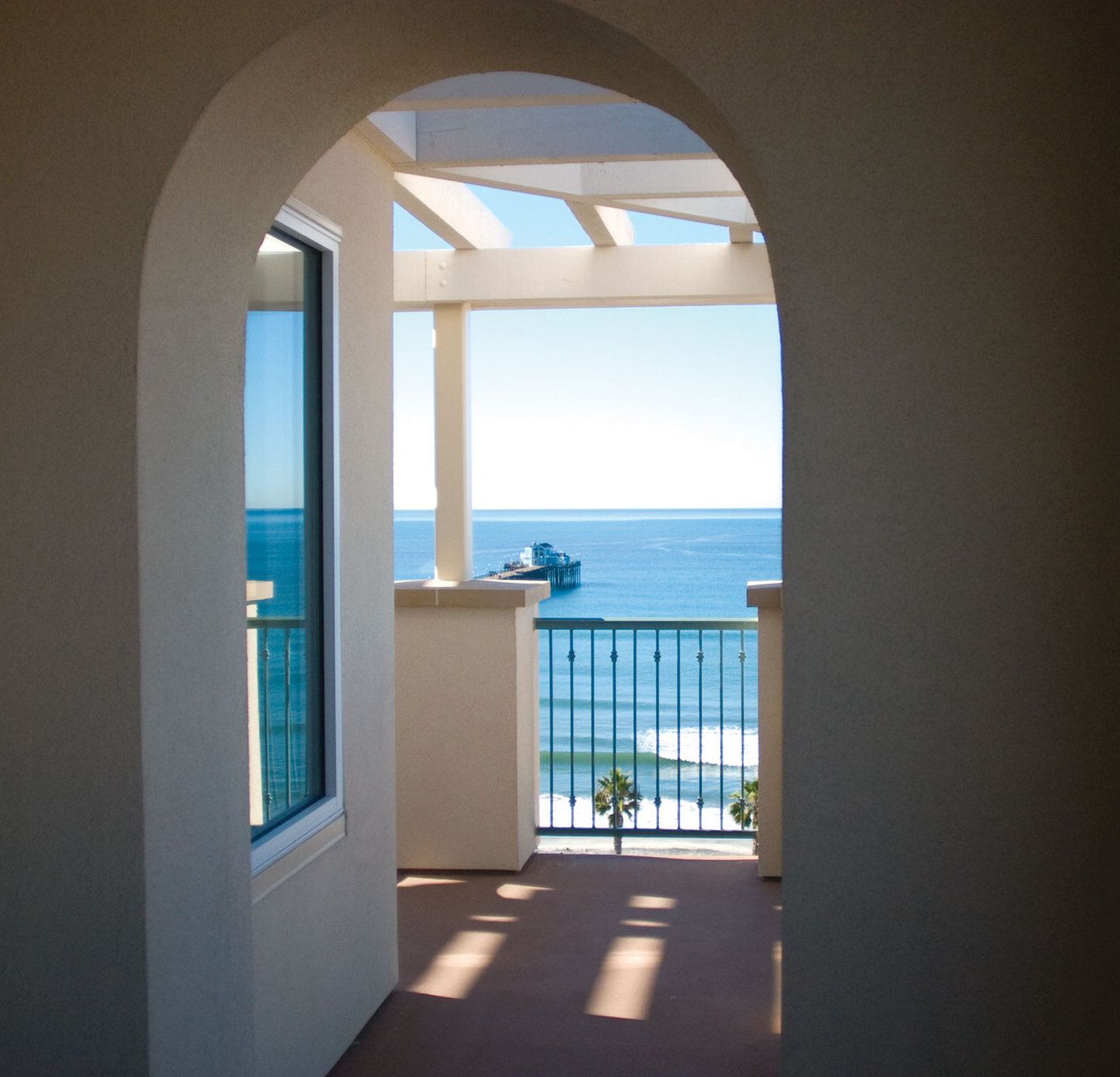 Ein Flur, der zu einem Balkon mit Meerblick führt.