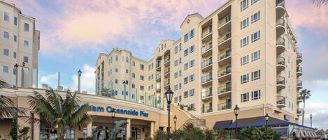 A hotel with multiple floors, balconies, and a central courtyard with benches and planters.