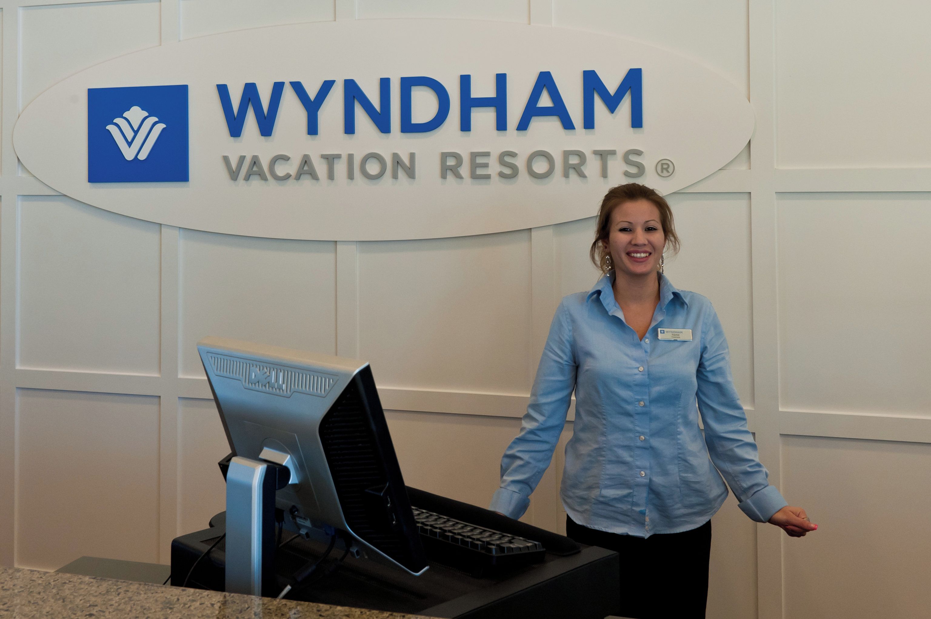 A reception desk at Wyndham Vacation Resorts with a computer and a name tag.