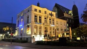 A historic building with a prominent "Golden Tulip" sign, a classic architectural style with a balcony, and a modern glass extension. - Golden Tulip West Ende (Helmond)