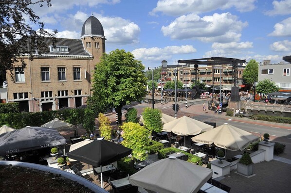 A hotel with outdoor seating and a prominent tower.