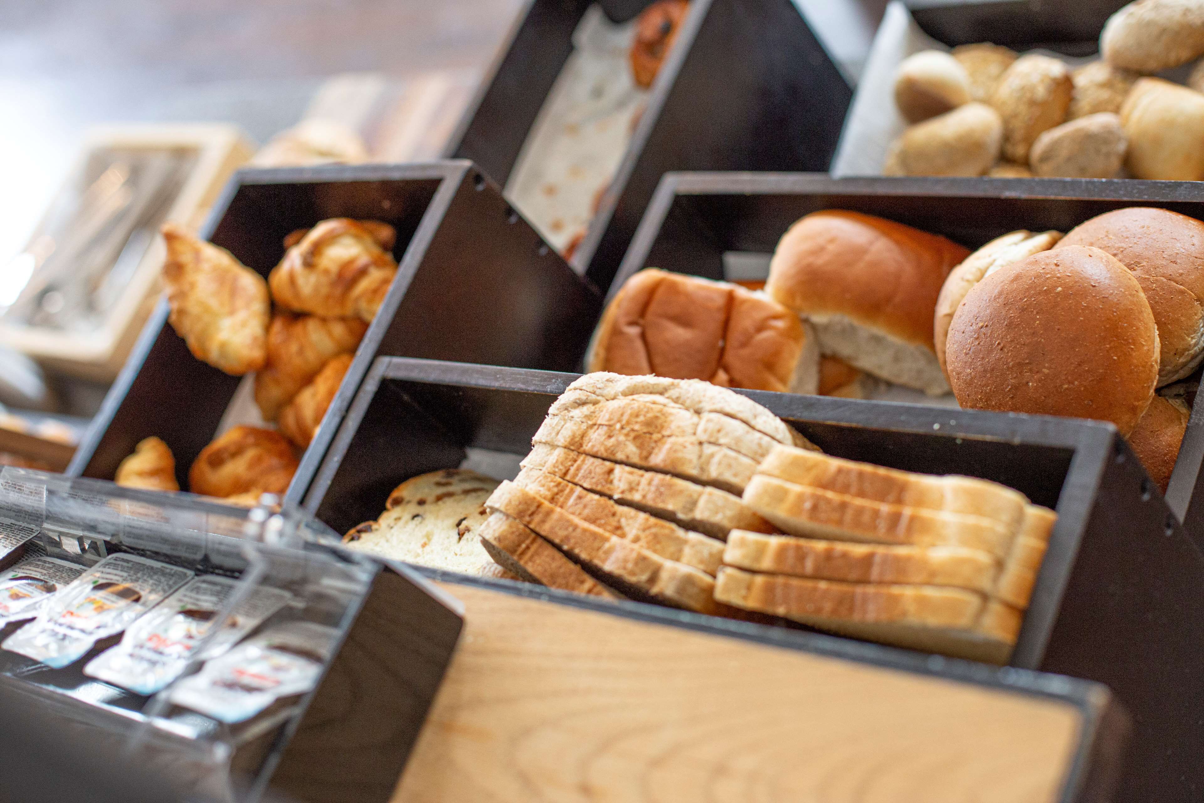Eine Bäckertheke mit verschiedenen Backwaren, darunter Croissants, Baguettes und Brötchen.