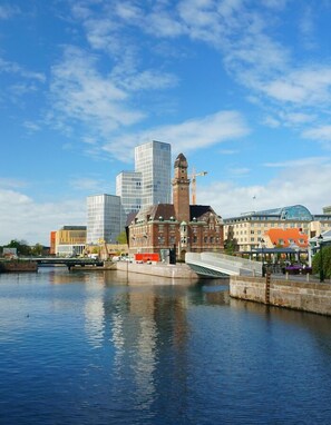 A riverside view of a city with historic buildings and modern skyscrapers. - TwentySix (Malmö)