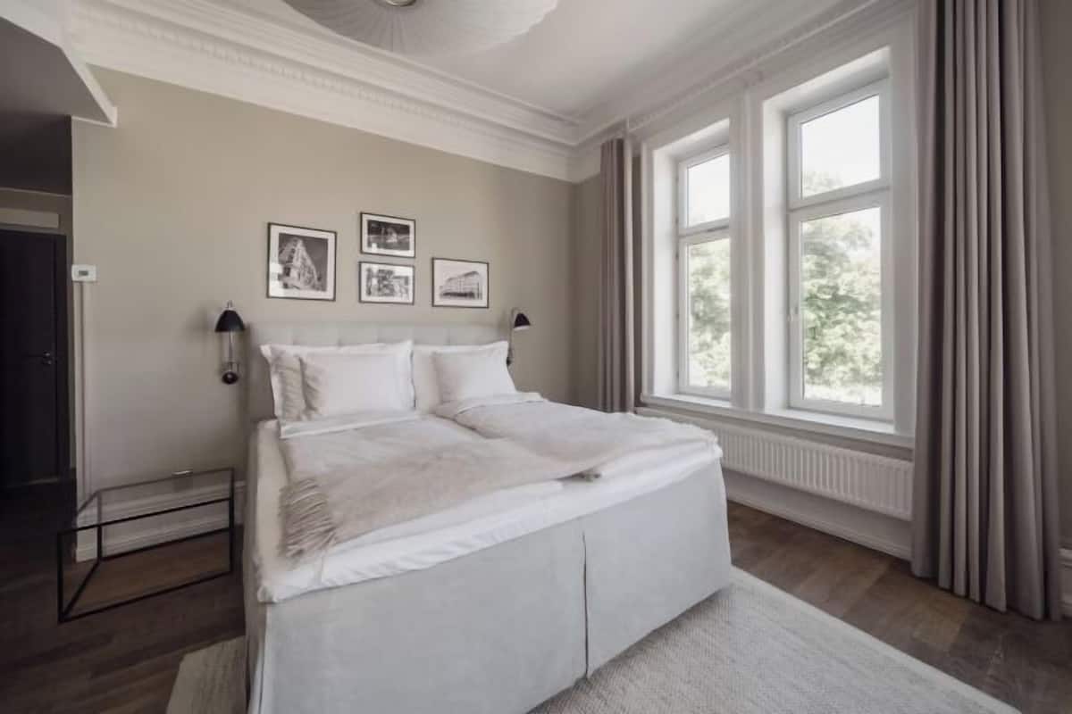 A bedroom with a bed, a window, and a radiator.