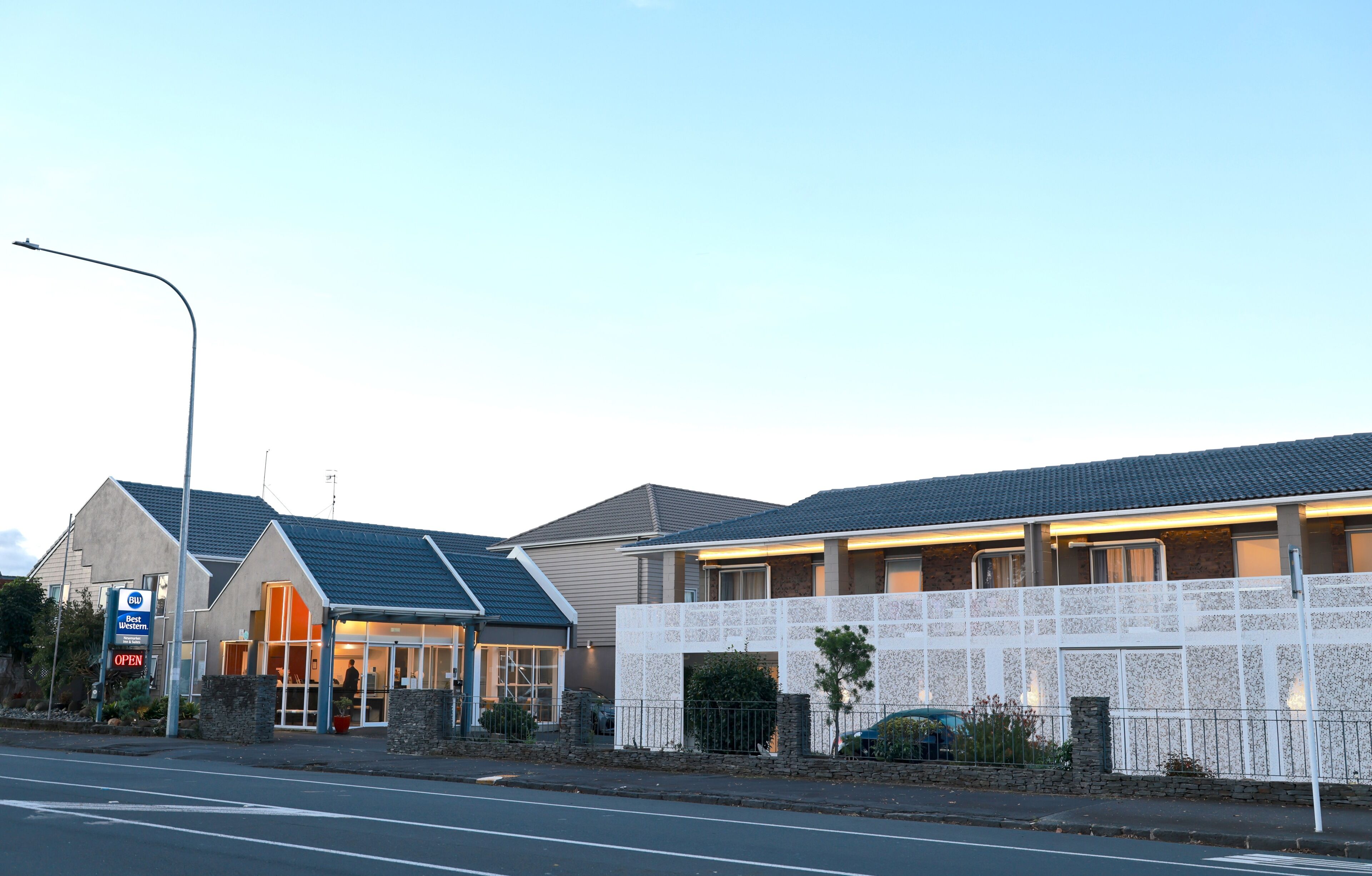 A building with a modern design, a parking sign, and a gated entrance.