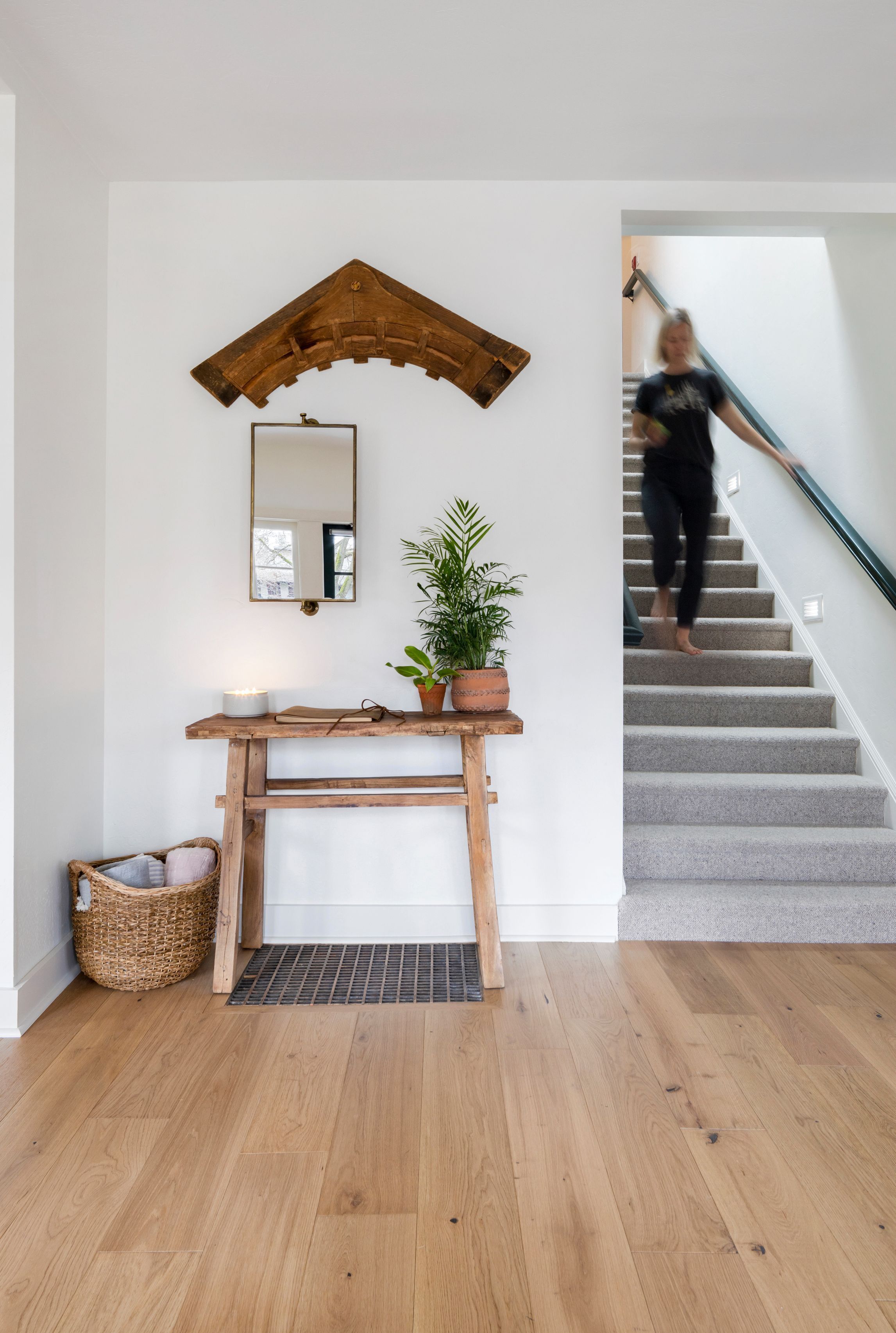 A staircase with a wooden handrail and a person ascending.