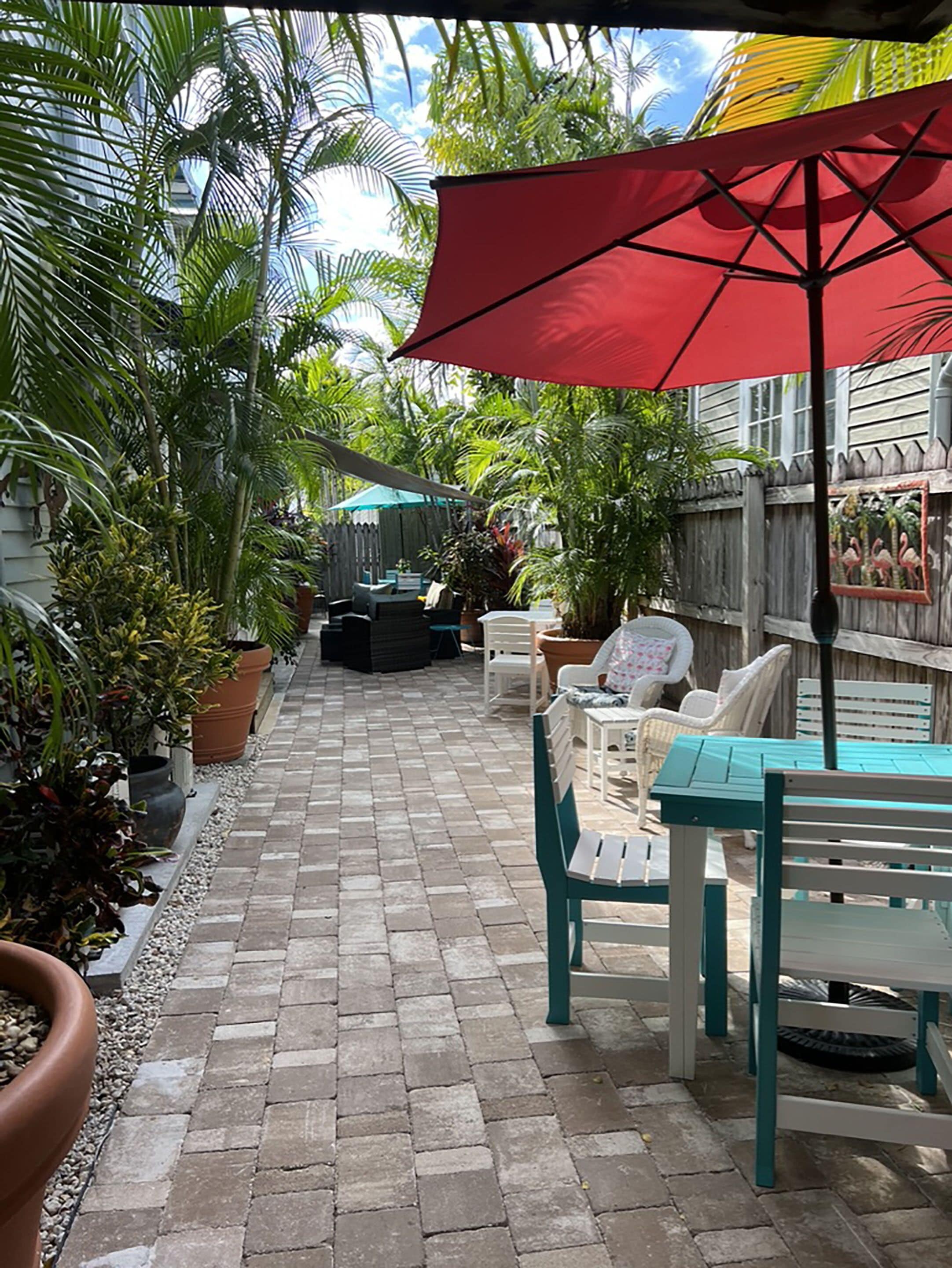 A paved patio with outdoor furniture and potted plants.