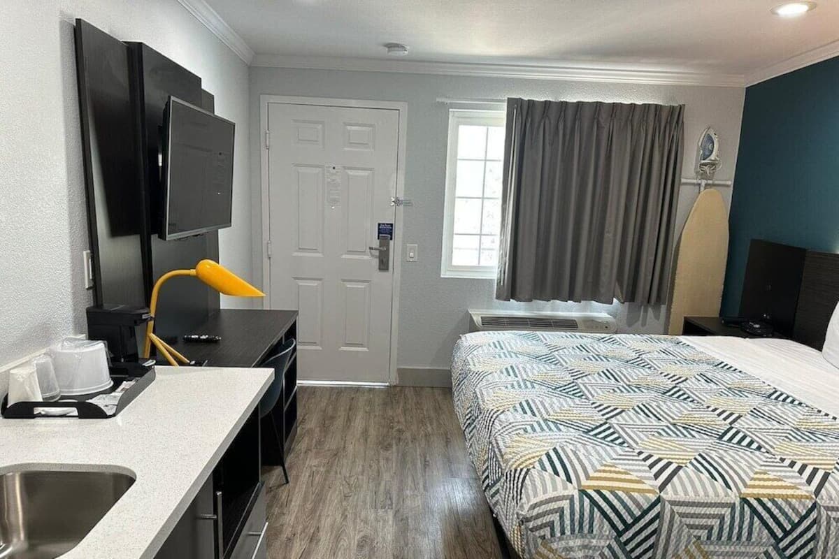 Escritorio, cortinas blackout y tabla de planchar con plancha