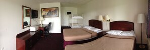 A hotel room with two beds, a desk, a chair, a TV, and a painting on the wall. - Budget Motel (Grand Island)