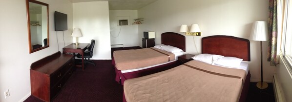 A hotel room with two beds, a desk, a chair, a TV, and a lamp. - Budget Motel (Grand Island)