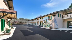 A hotel with a central courtyard, multiple balconies, and a mural on the building. - Quality Inn Downtown Helen (Helen)