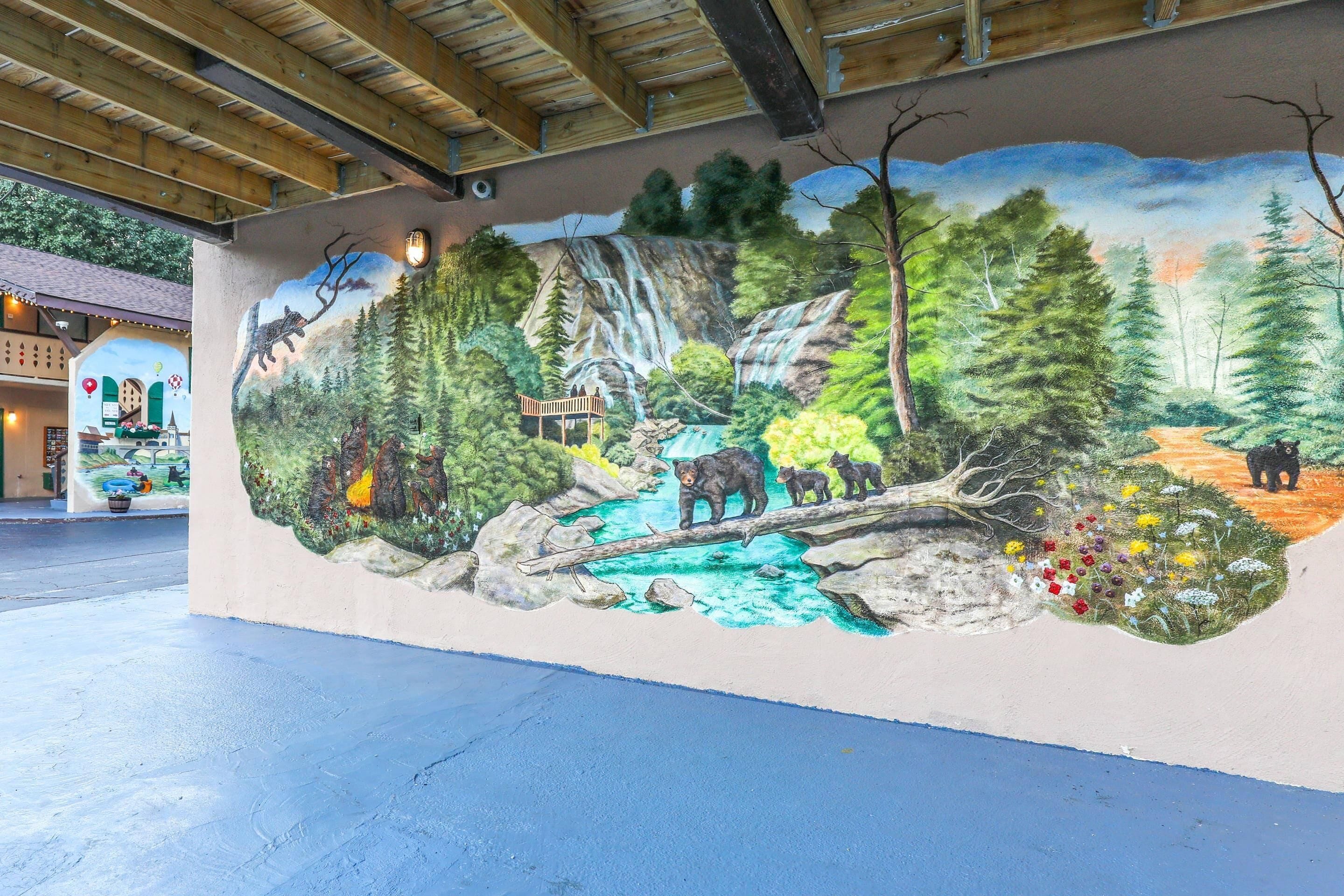 Une fresque représentant une scène de forêt avec une cascade, un pont en bois et des ours.