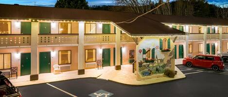 A motel with multiple rooms, a parking area, and a small outdoor seating area.
