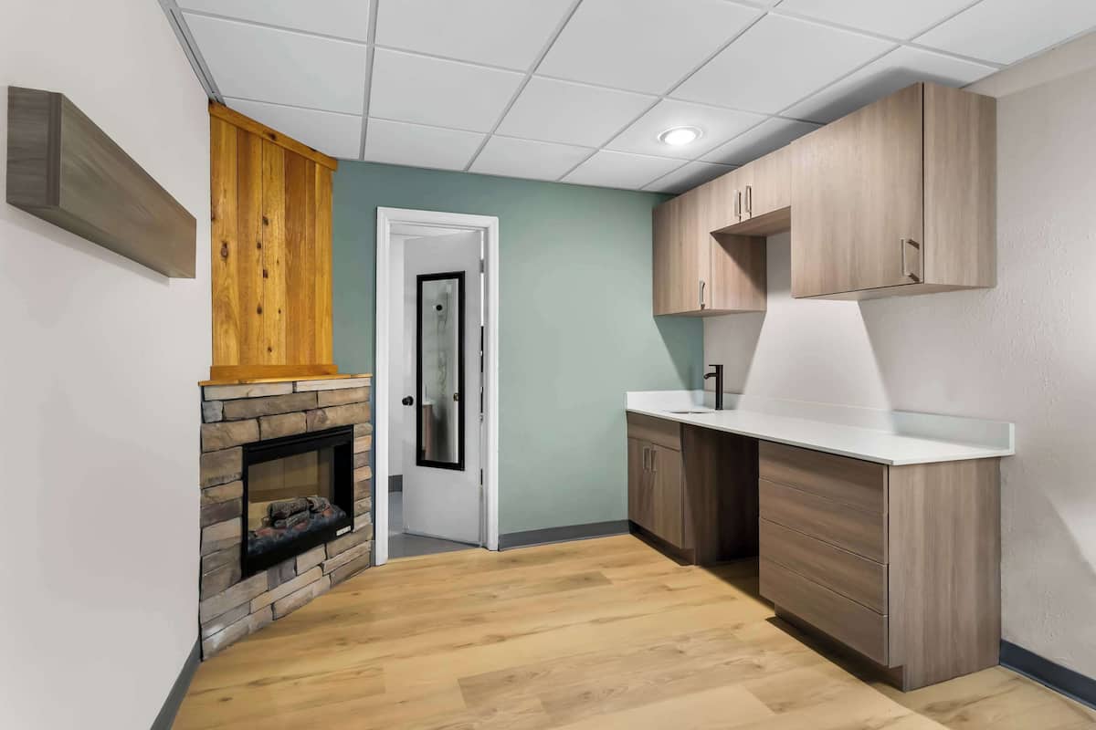 A modern kitchen with wooden cabinets, a built-in stove, and a white countertop.